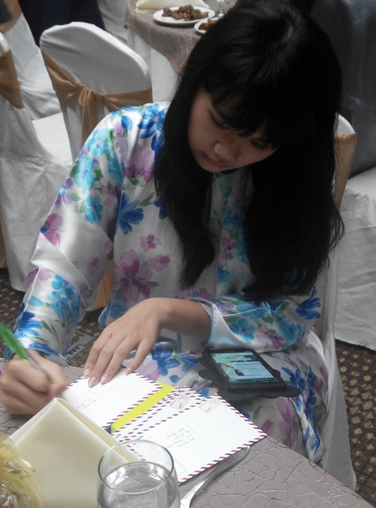 Miriam sungguh kusyuk menulis poskad