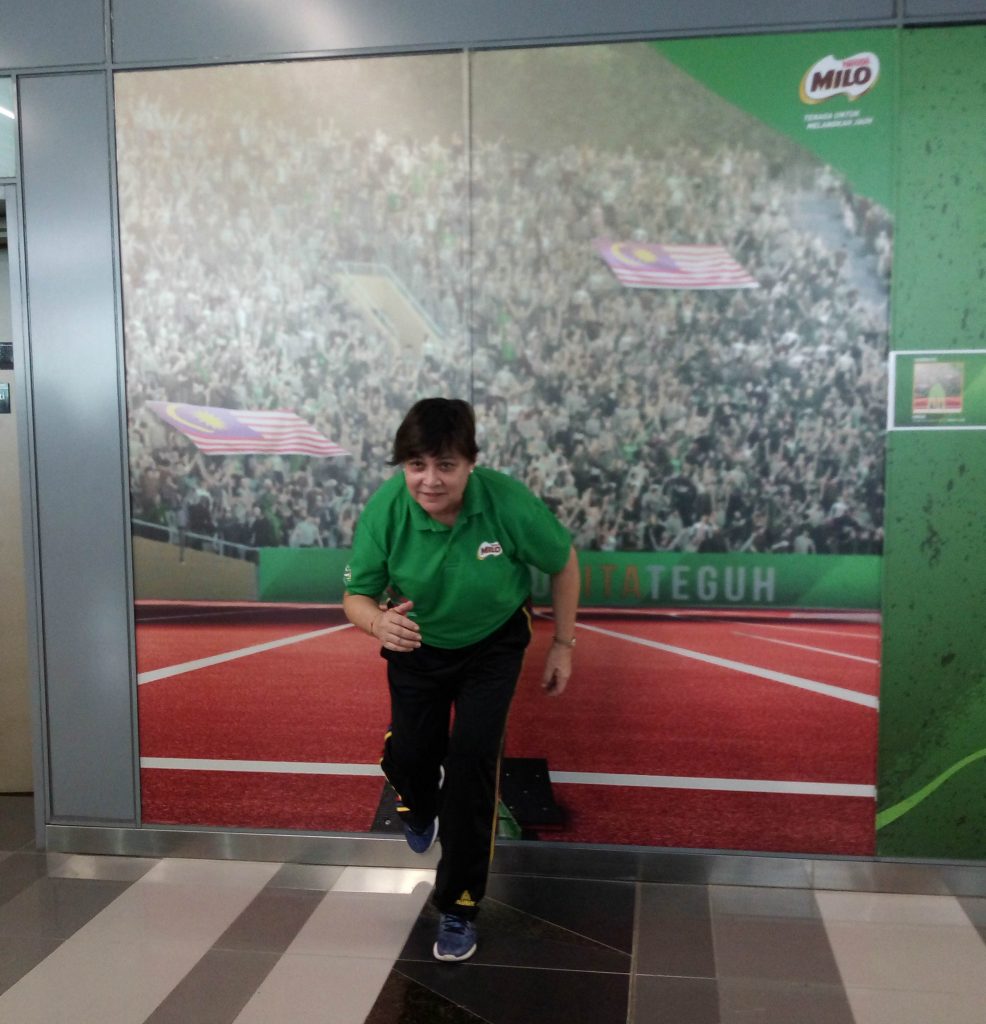 Datuk Marina Chin menggayakan larian di depan photo wall