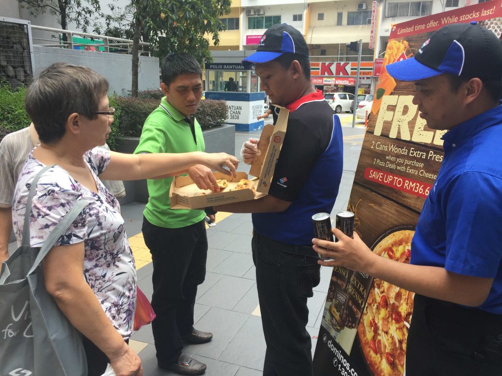 Orang ramai mencuba pelbagai pizza yang disajikan oleh Domino's Pizza